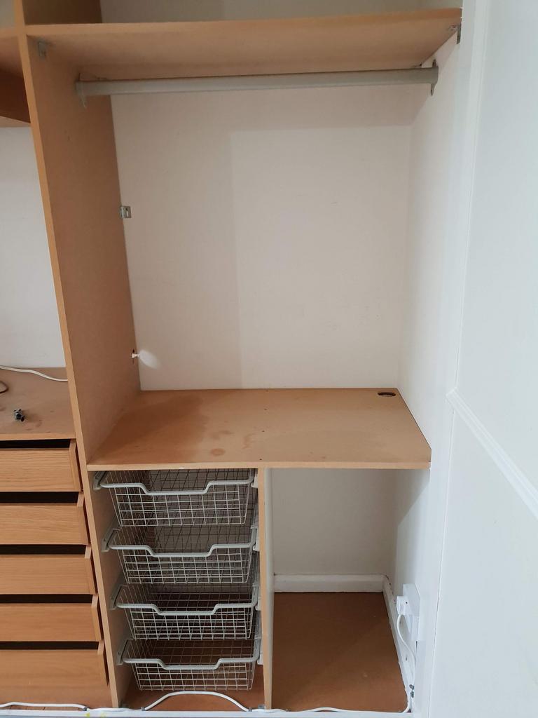 Built-in wardrobe/storage area with hanging rai...