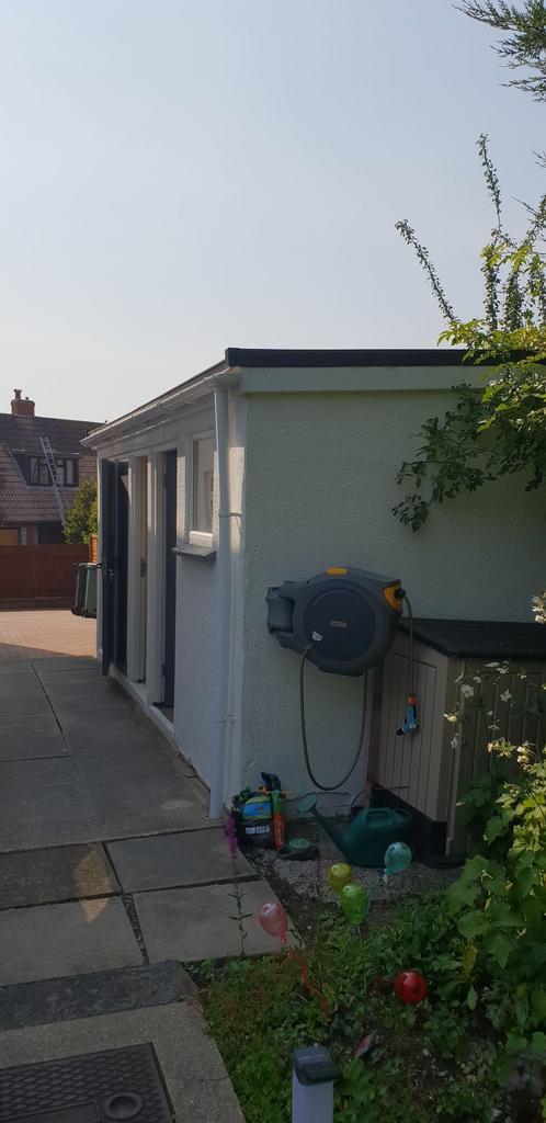 Sunny paved side garden with a neat pathway, st...
