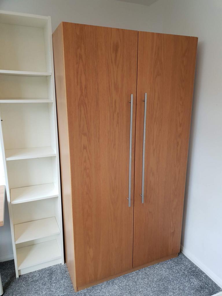 Well-presented bedroom storage with a tall wood...