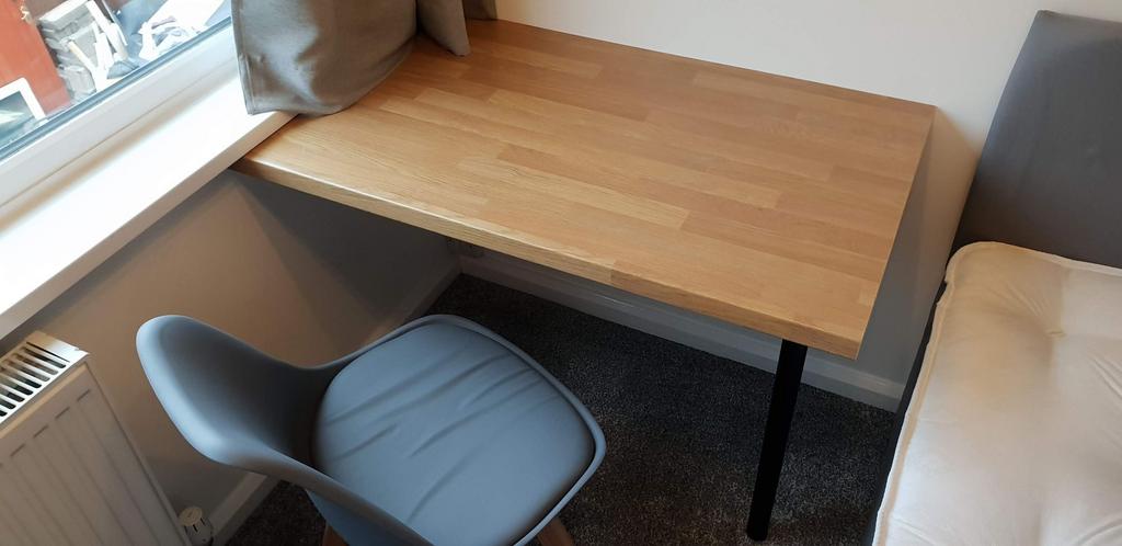 Bright, tidy bedroom corner with a built-in woo...