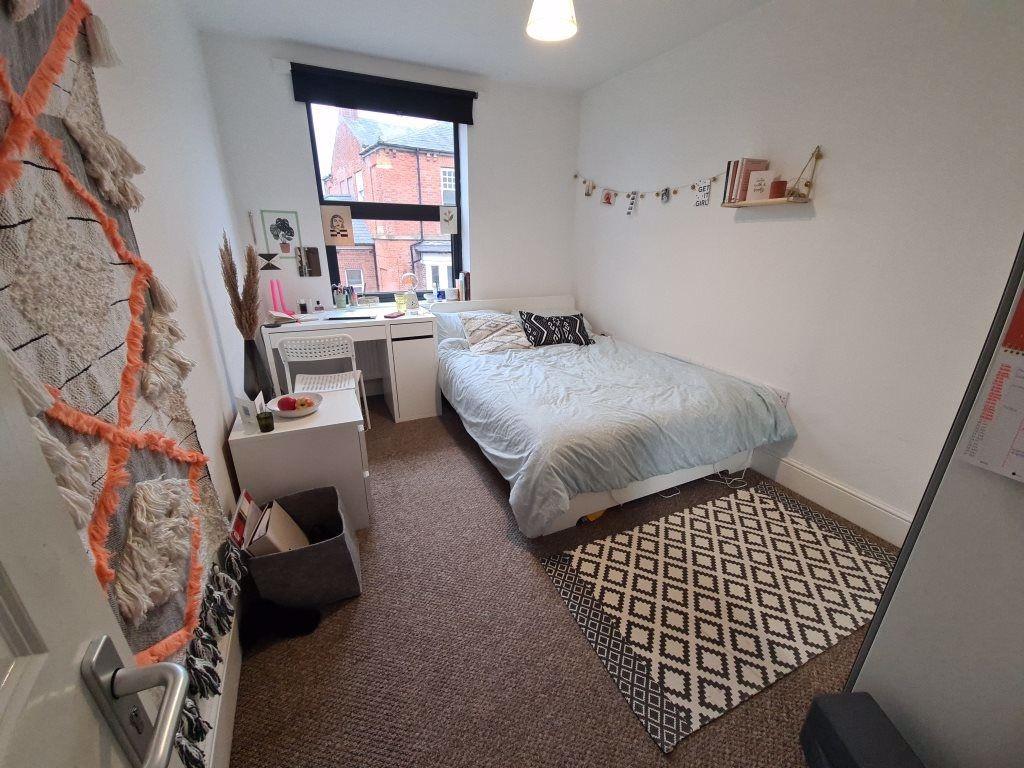 A cozy, well-kept single bedroom featuring a co...