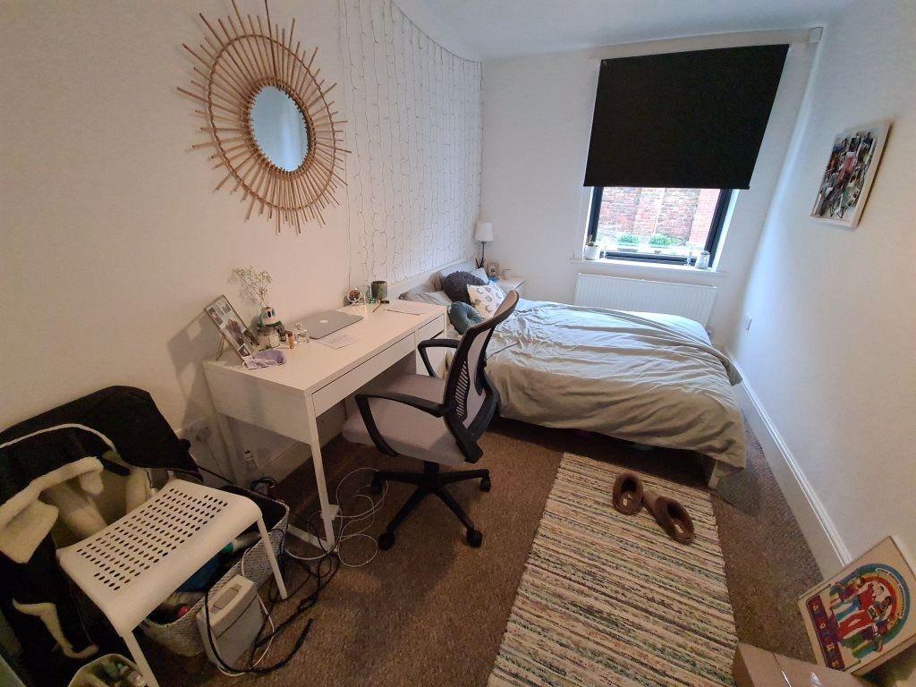 A neat and cozy single bedroom featuring a comf...