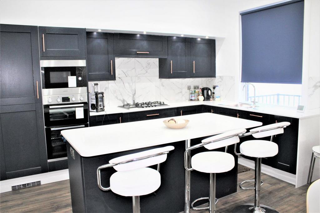 Modern kitchen with sleek black cabinetry, a wh...