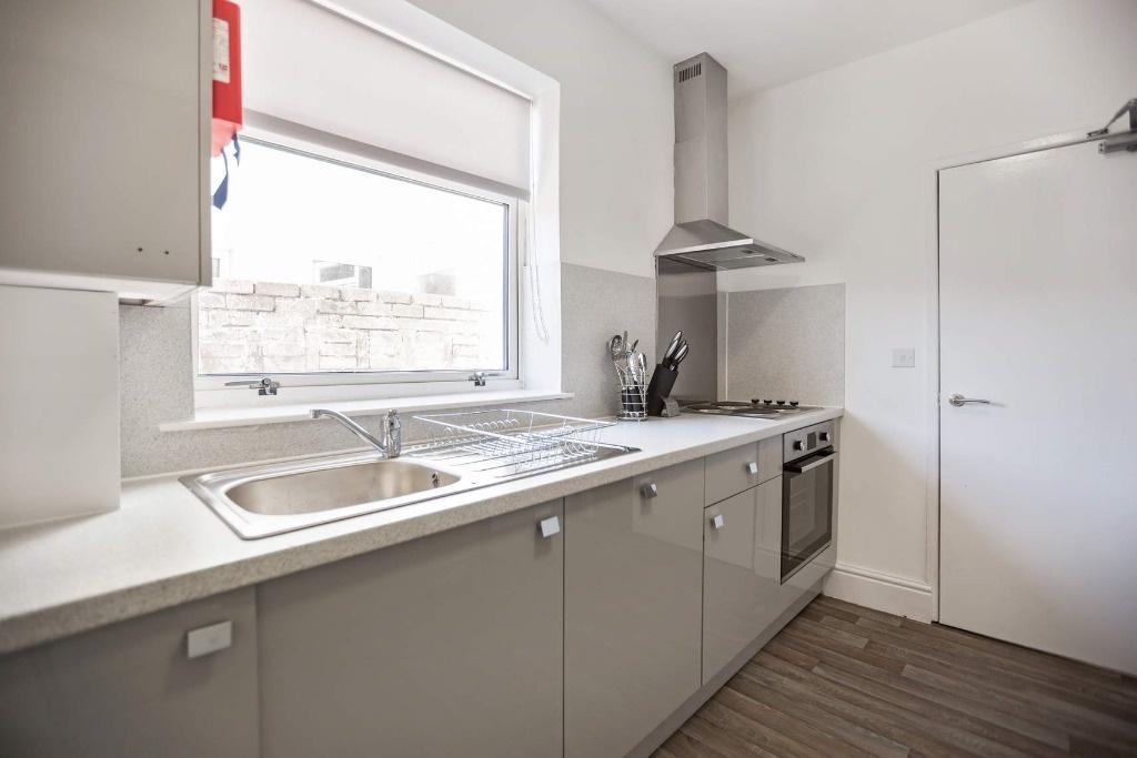 Bright modern kitchen with sleek gloss cabinetr...