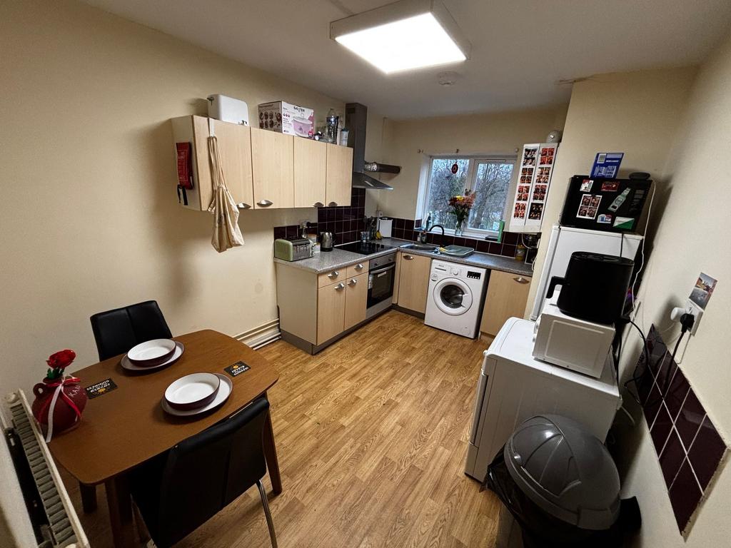 Well-equipped kitchen with wood-effect flooring...