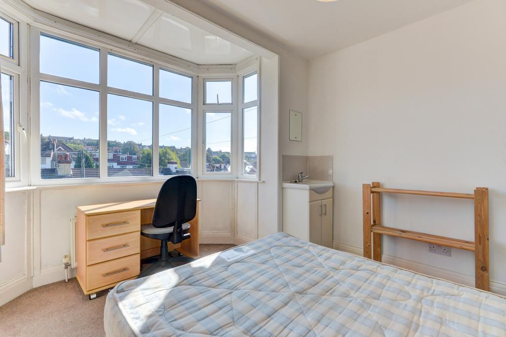 Bright bedroom with a large bay window offering...