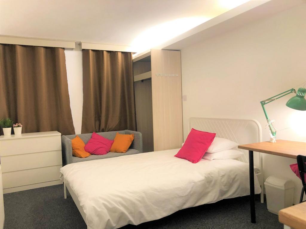 A cozy single bedroom featuring a comfortable b...