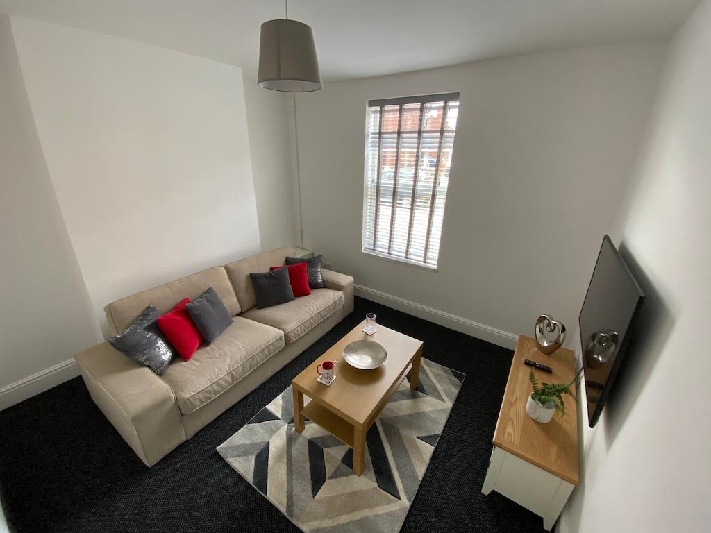 Bright, neatly furnished living room with a com...