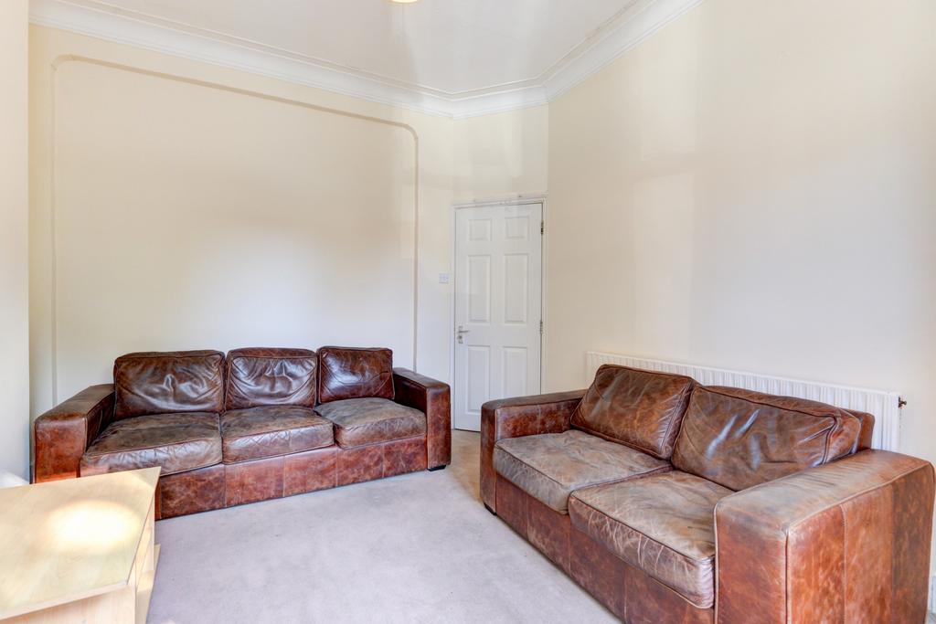 Bright, neutral living room with high ceilings,...