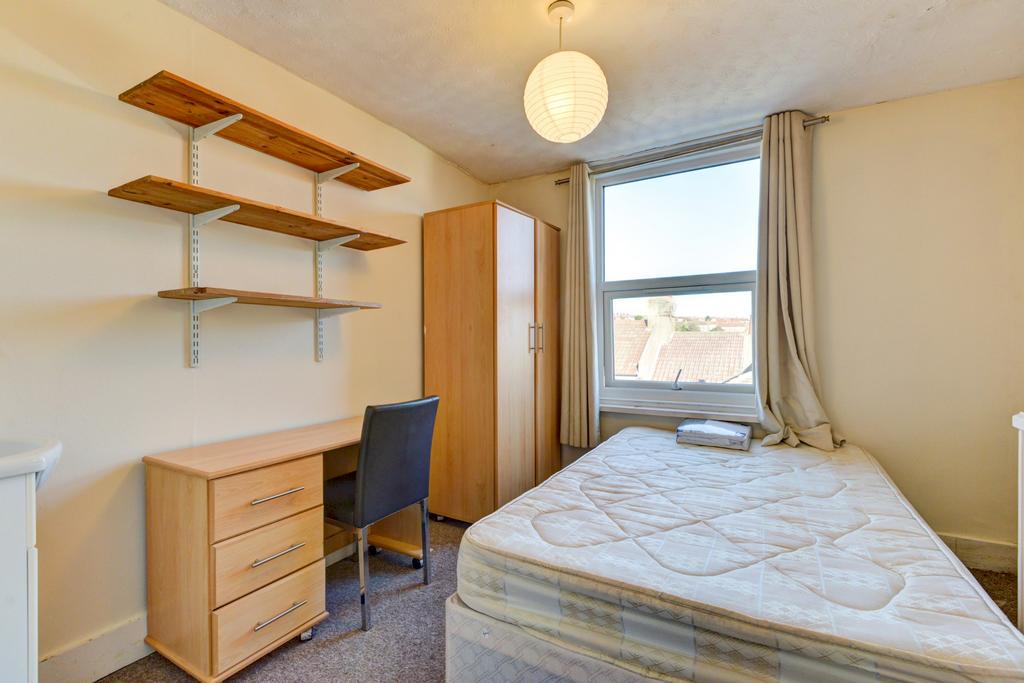 Bright, simply furnished bedroom with a comfort...