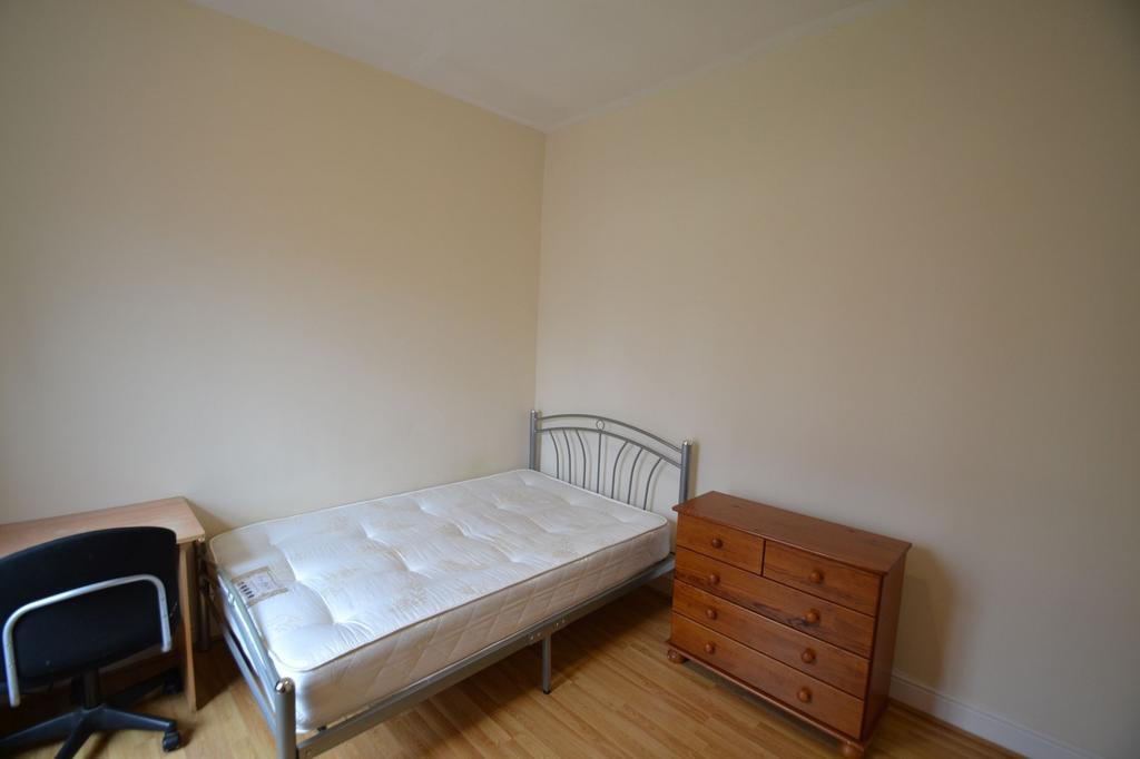 A simple, tidy single bedroom featuring a metal...