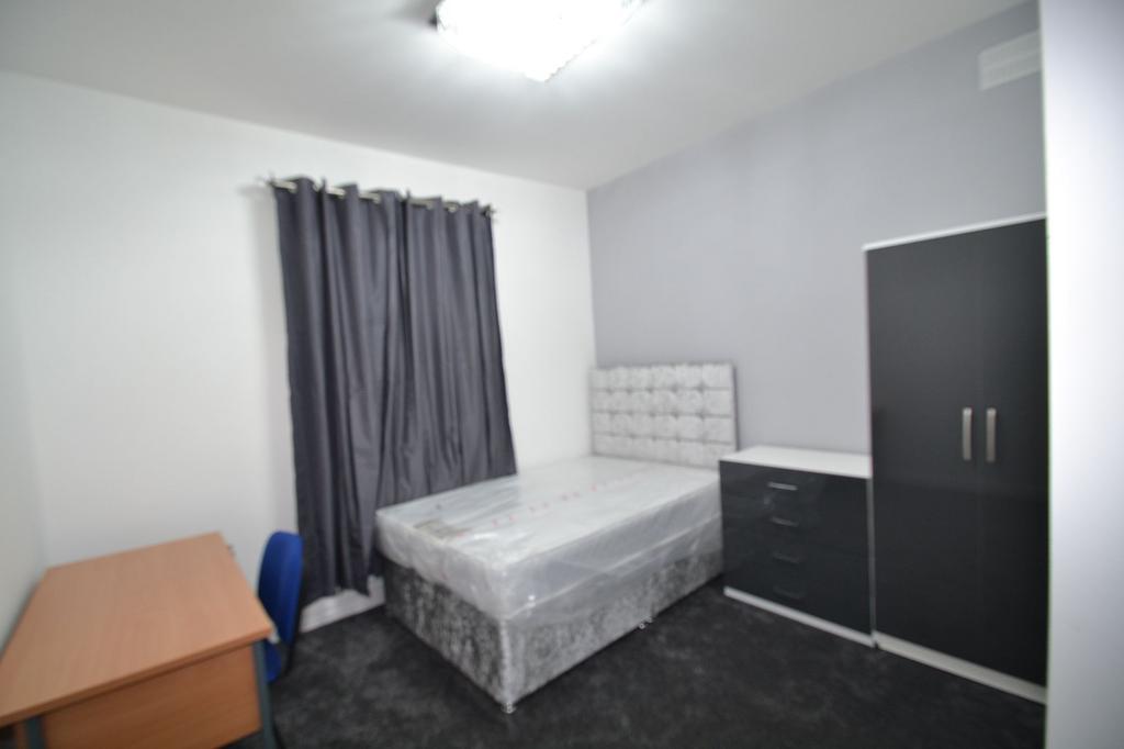 Neat furnished bedroom with a double bed, match...
