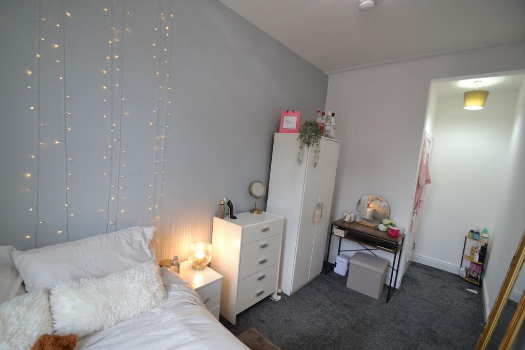 A cozy bedroom featuring a bed with white linen...