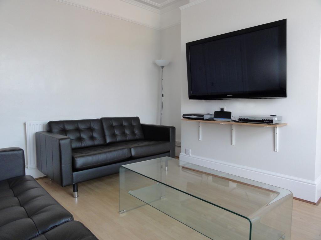 Modern living room featuring a sleek black leat...