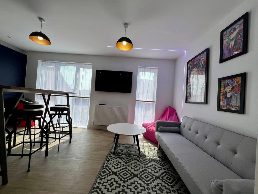 Bright, modern living room with a long grey sof...