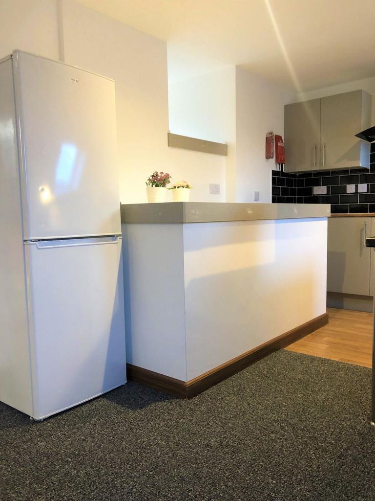 A modern kitchen area featuring a clean white f...
