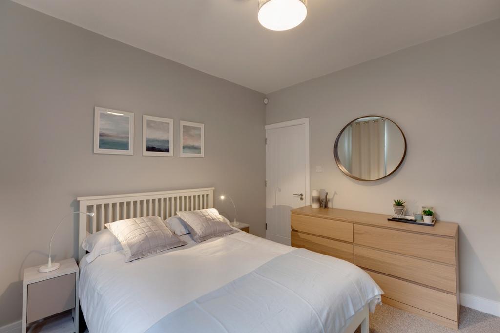 Bright, modern double bedroom with a neat white...