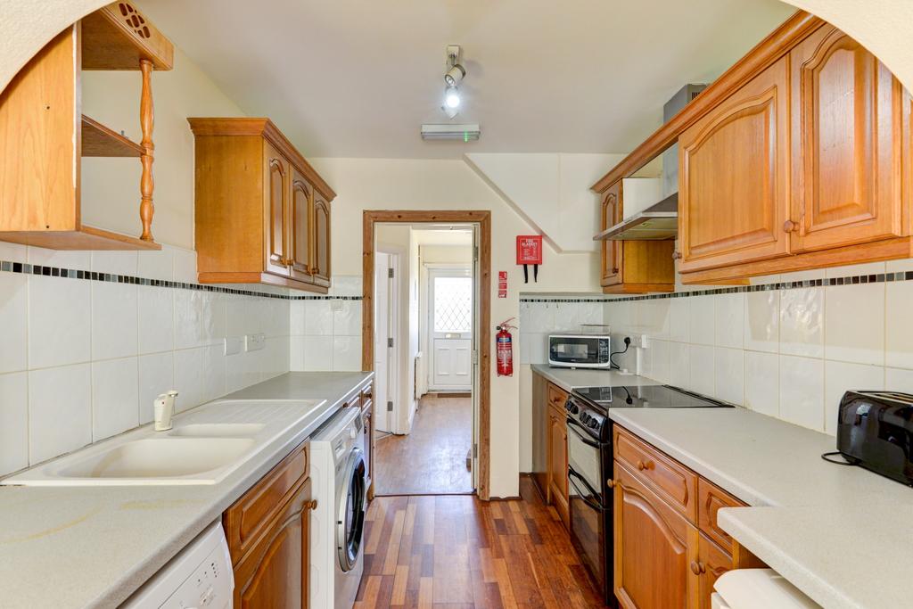 A well-maintained kitchen with wooden cabinets,...