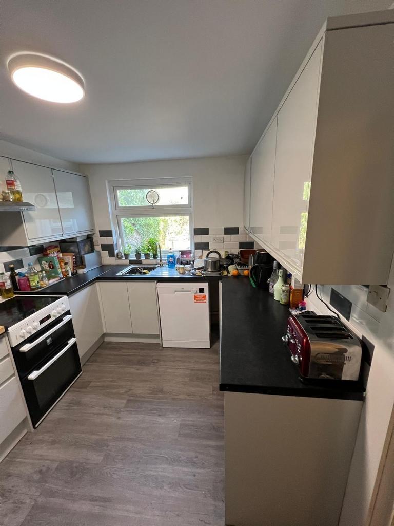 Modern galley-style kitchen with white cabinets...