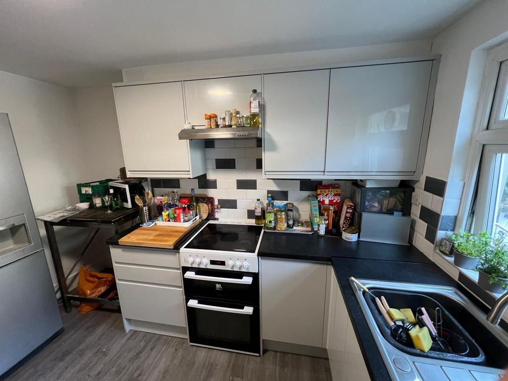Modern galley kitchen with white cabinetry, int...