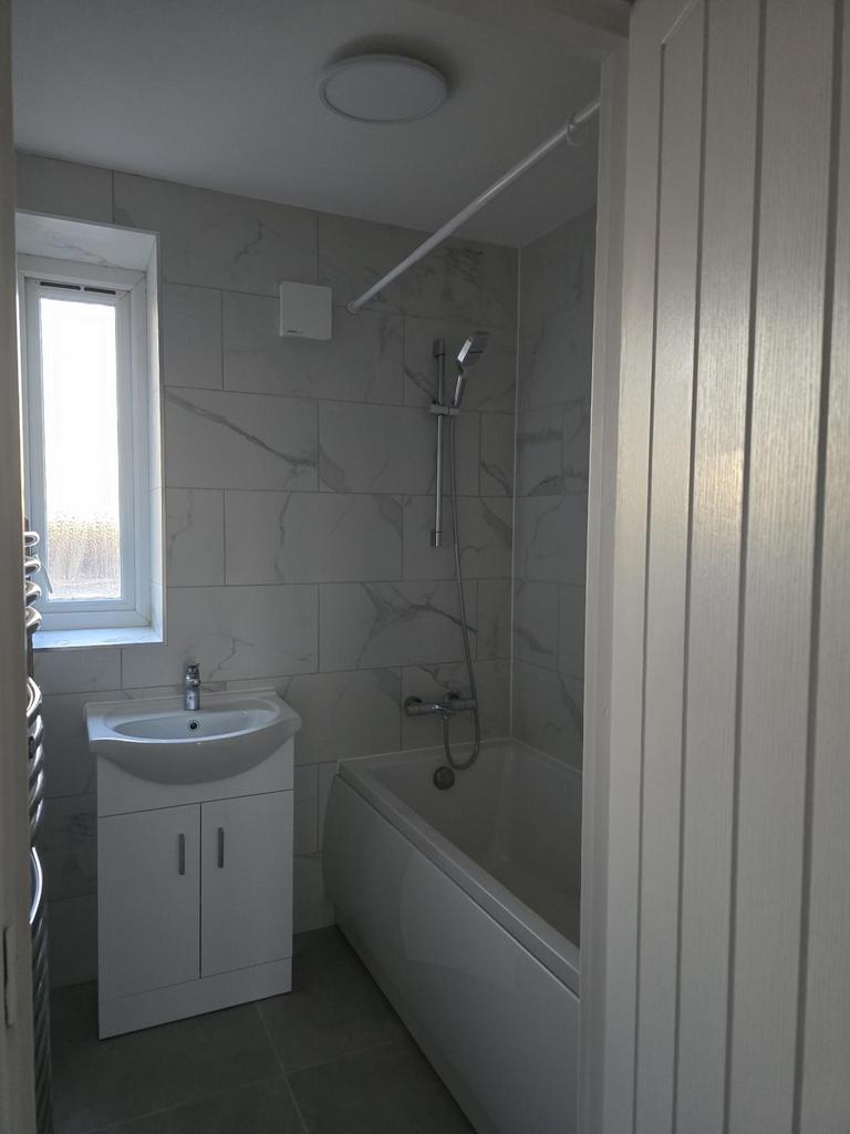 Newly renovated bathroom with modern tiling, full