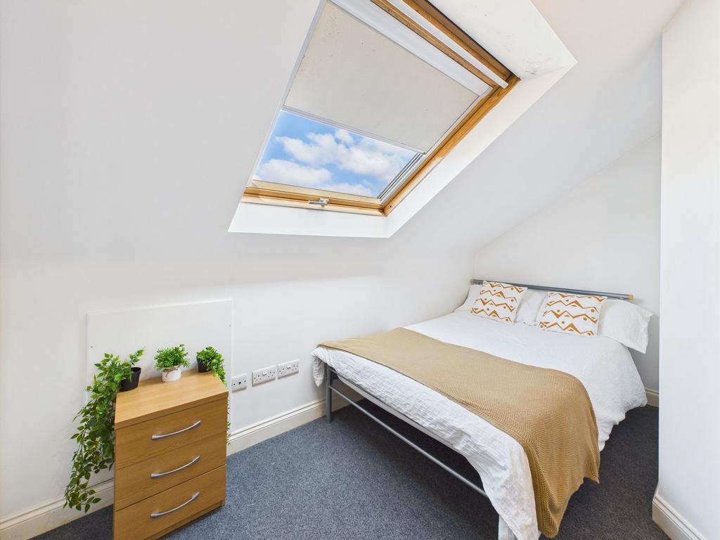 Bright, neatly styled double bedroom with a sky...