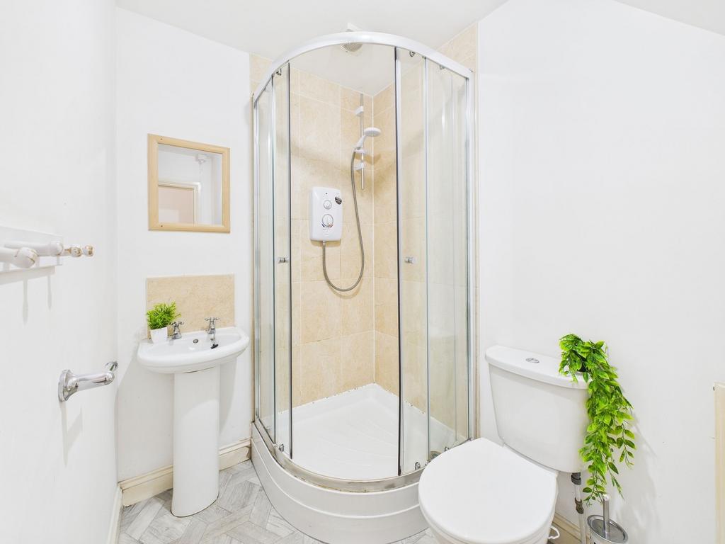Bright, well-kept bathroom with a corner glass ...