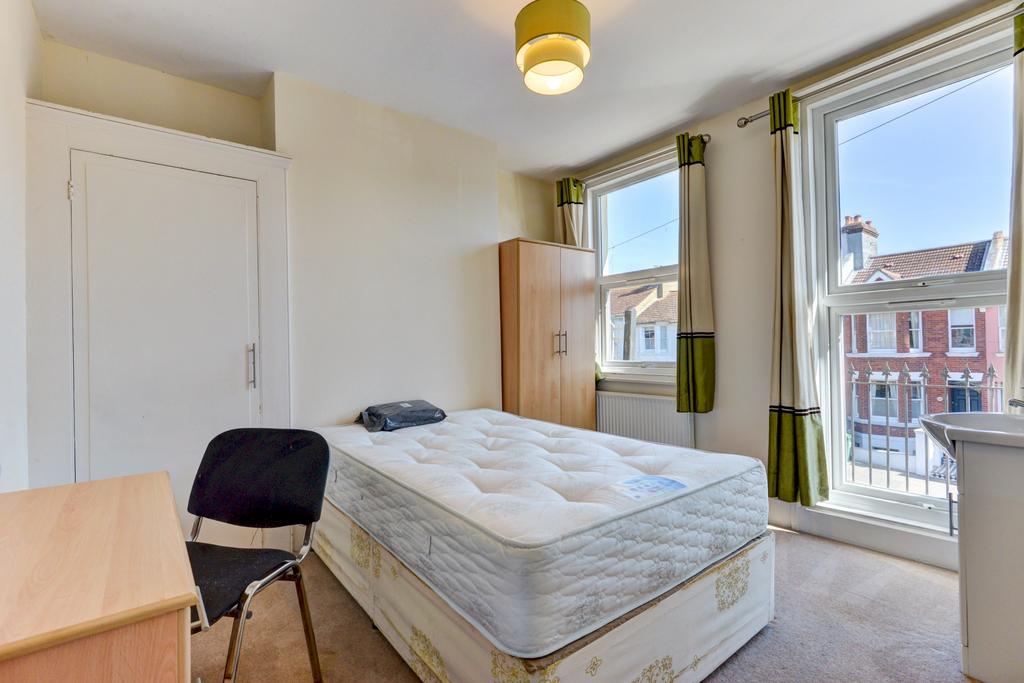 A bright and welcoming bedroom with large windo...