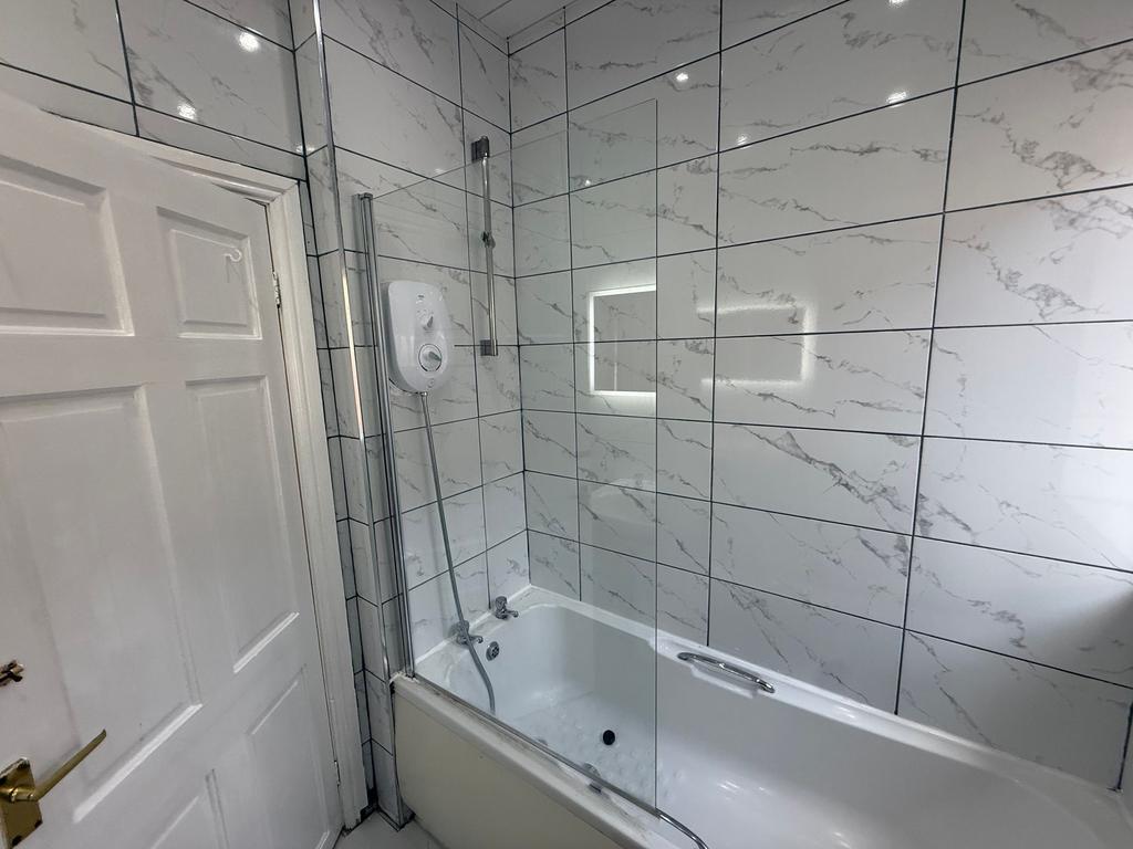Bright, modern bathroom with a white bathtub, g...