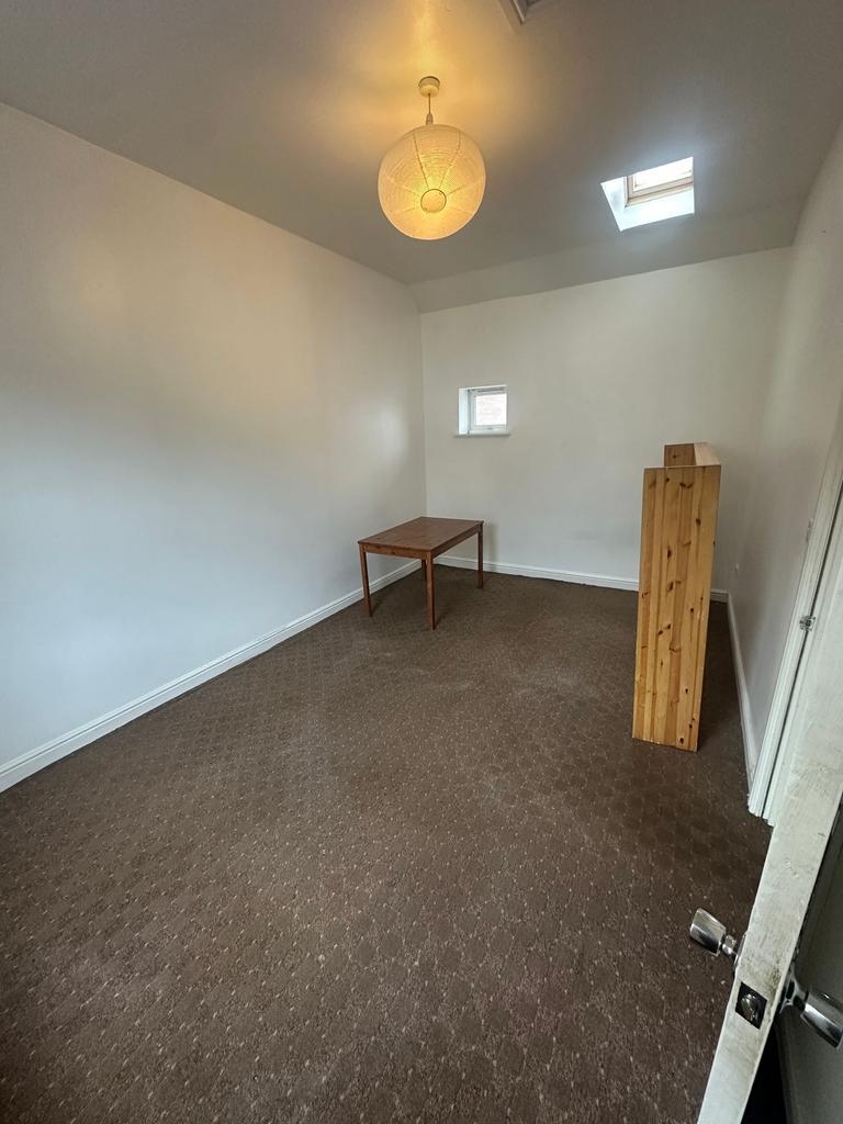 Bright, simply furnished room with neutral whit...