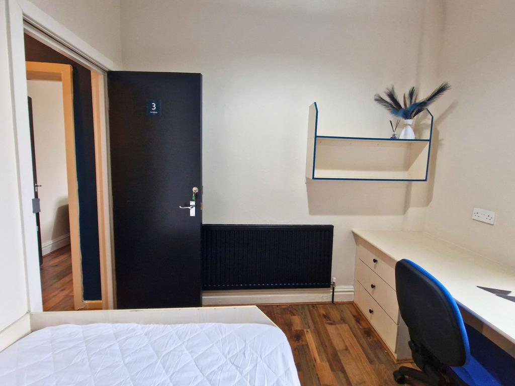 Neat single bedroom with a fitted desk and draw...