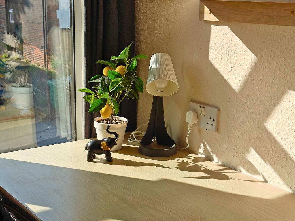 Bright, sunlit workspace by a large window with...