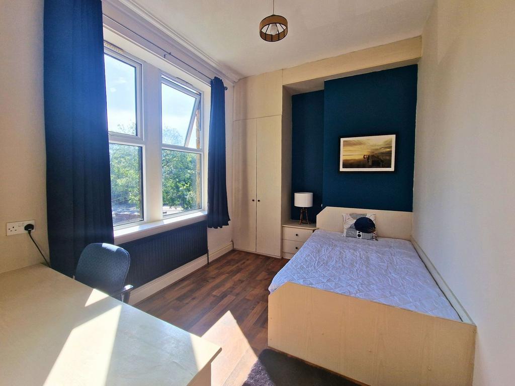 Bright single bedroom with a large sash window ...