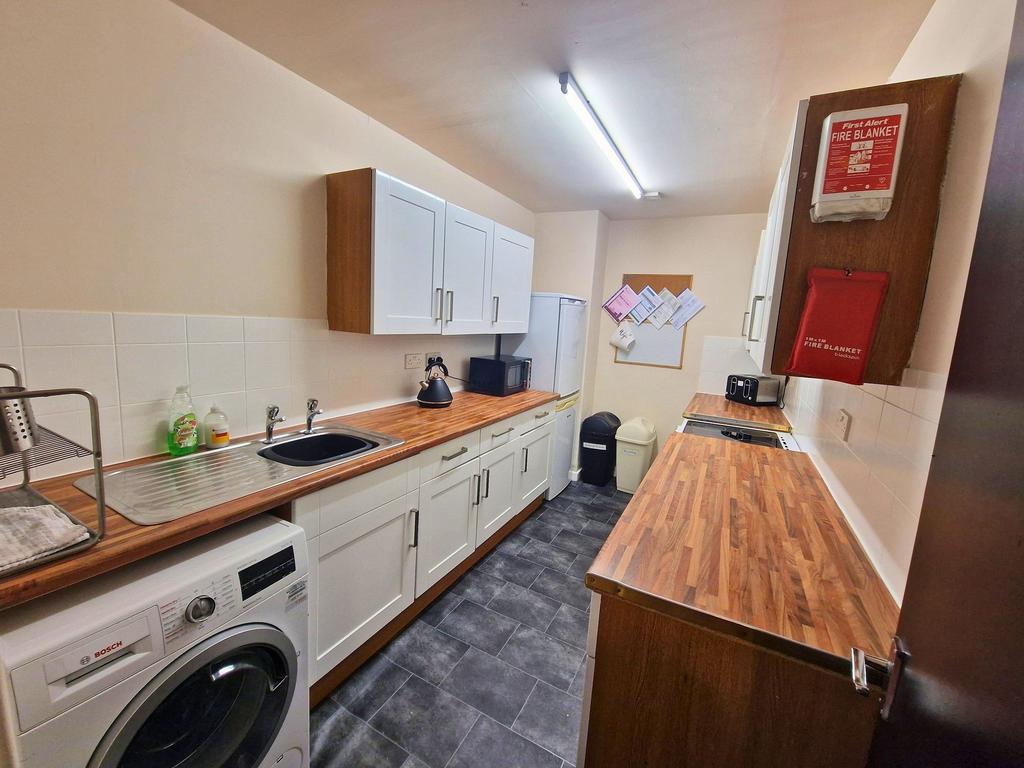 Bright, well-equipped galley kitchen with wood-...