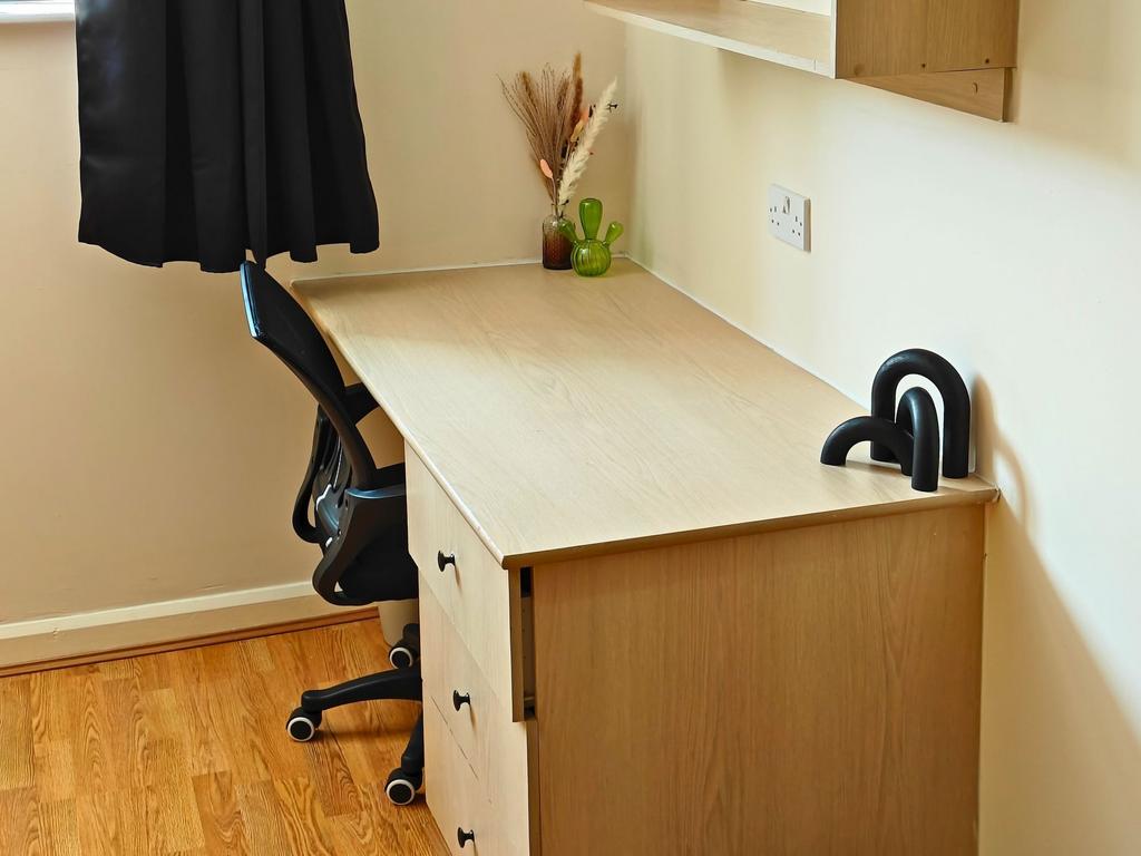 Neat, light-filled study area with a long woode...