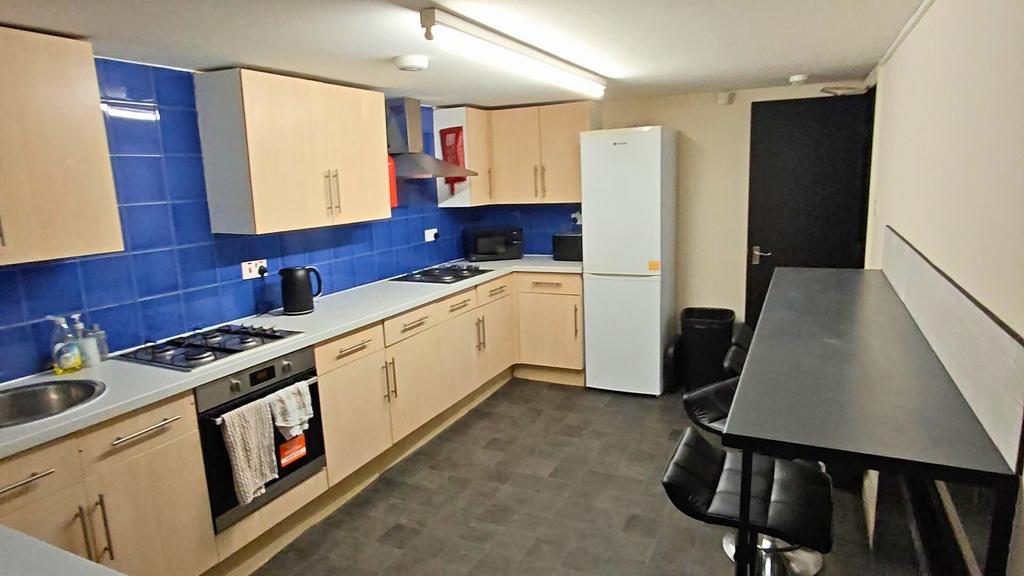 Bright communal kitchen with a long worktop, bl...