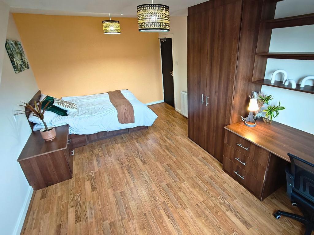 Bright, well-furnished bedroom featuring a comf...