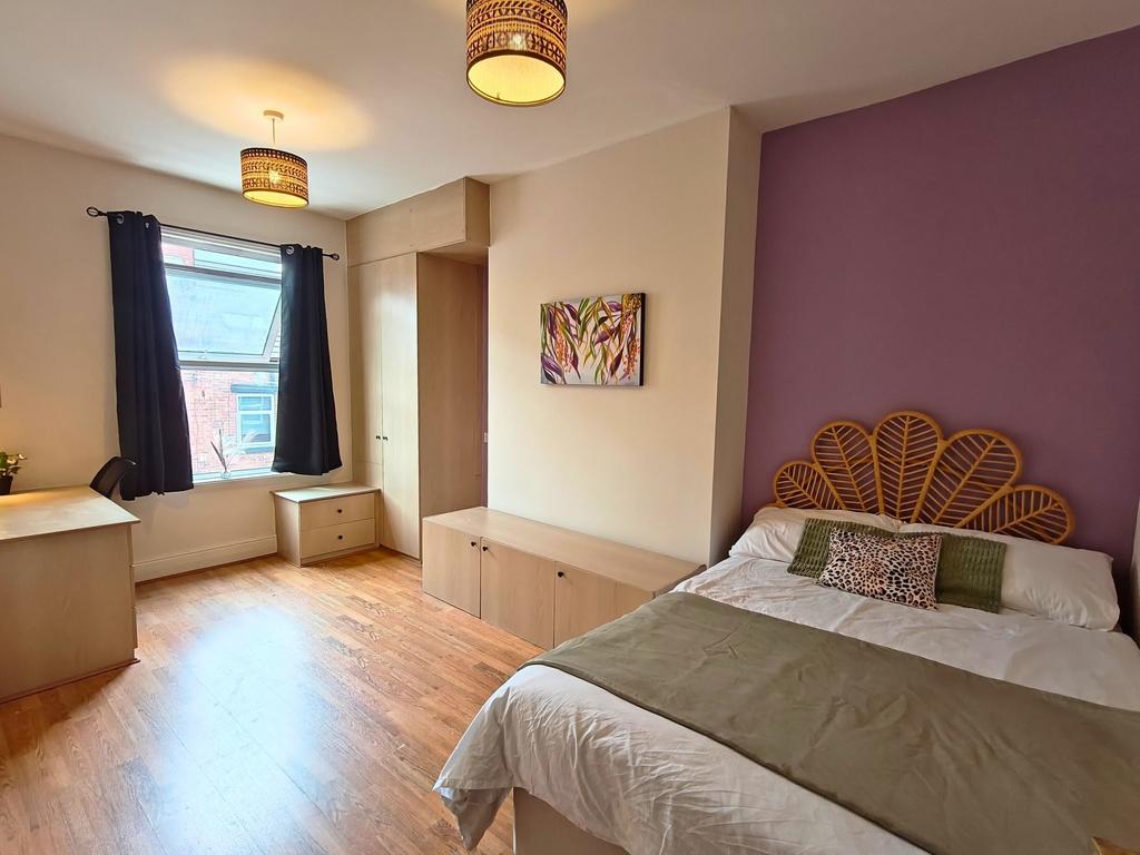 Bright, well-presented bedroom with warm wood f...