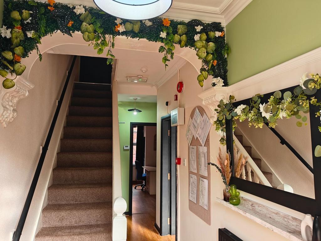 Welcoming entrance hallway with carpeted stairs...