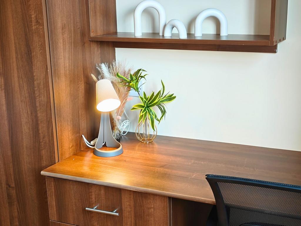 Well-lit wooden workspace with integrated shelv...