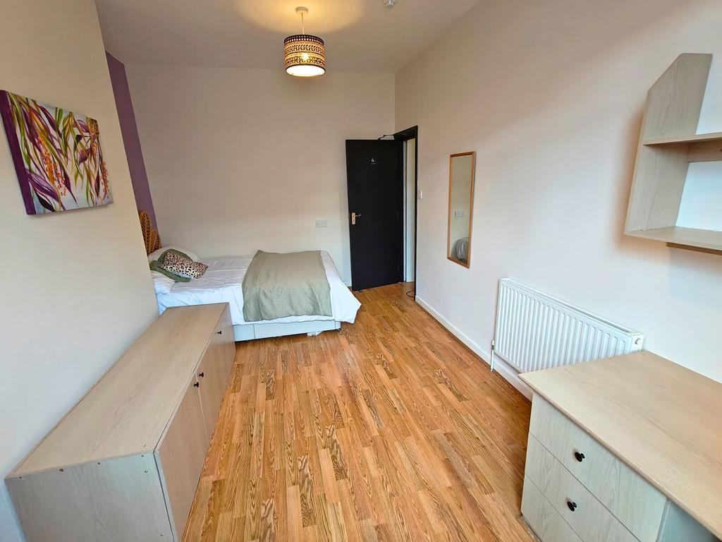 Bright, tidy bedroom with warm wooden flooring,...