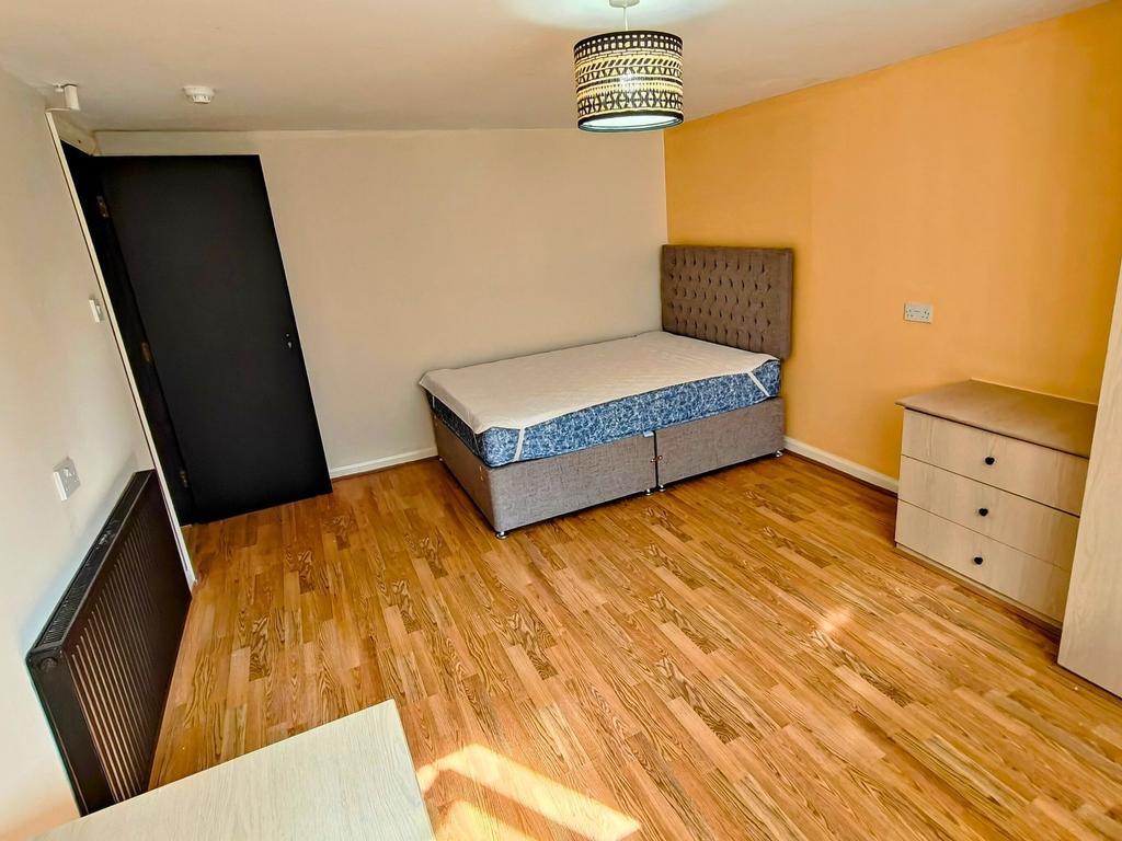 Bright, well-kept bedroom with wooden flooring,...