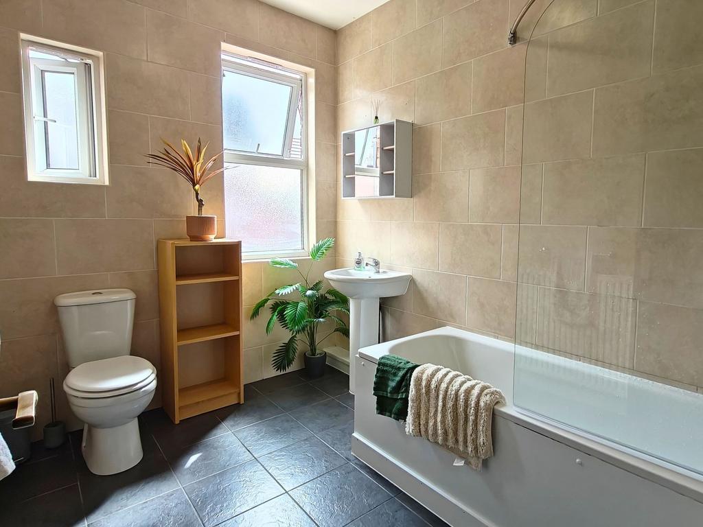 Bright, modern bathroom with large frosted wind...