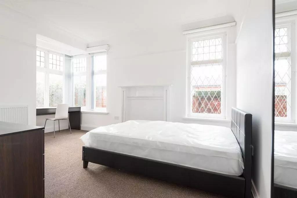 Bright, airy bedroom with large bay windows, cl...