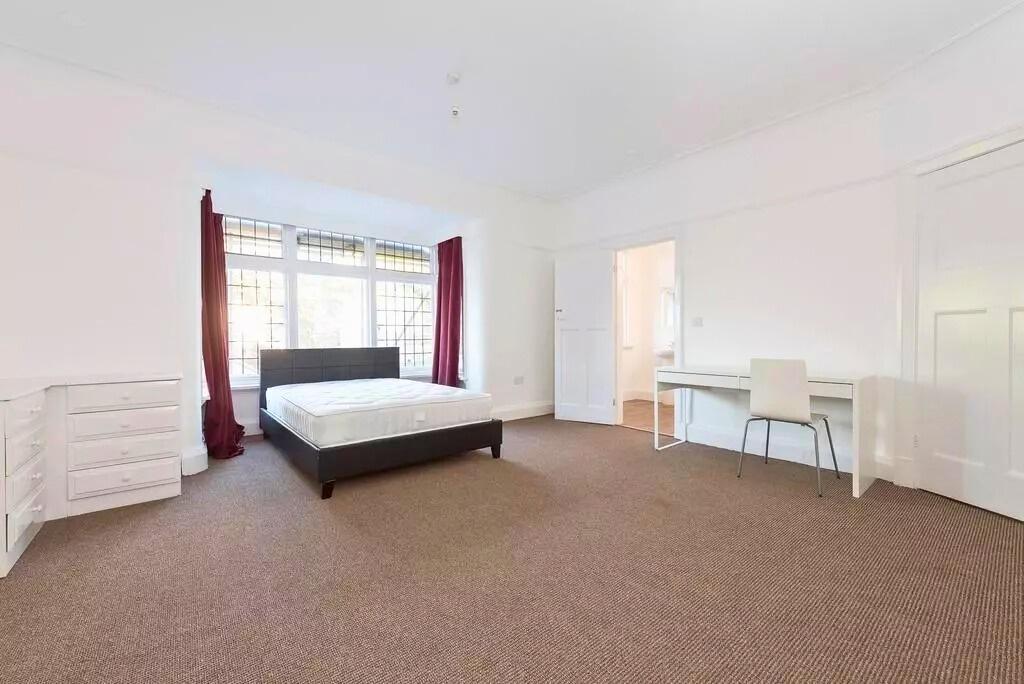 Bright, spacious bedroom with a large bay windo...