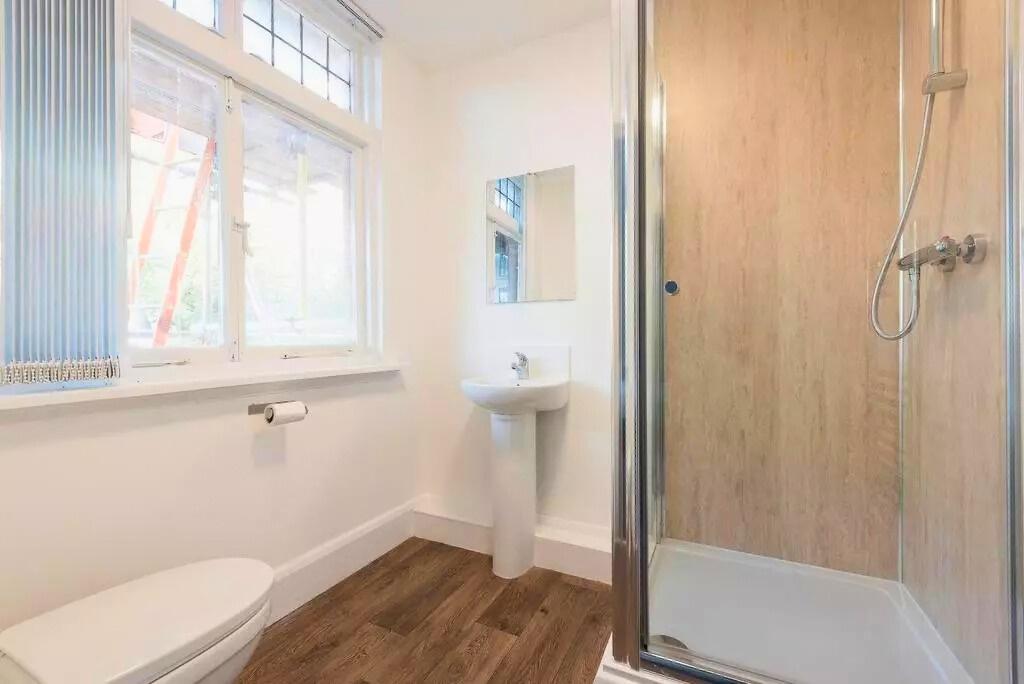 Bright, modern bathroom with a walk-in shower f...