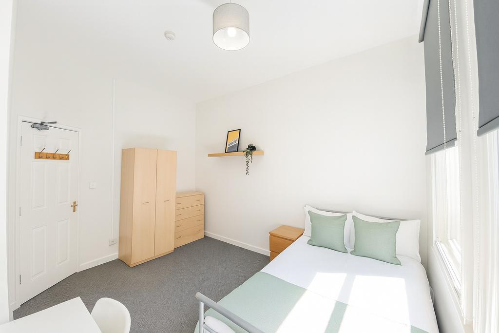 Bright and minimalist bedroom featuring a neatl...