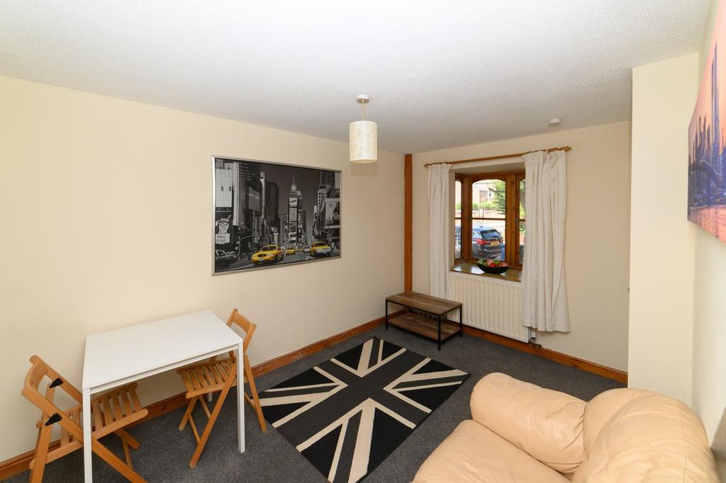 Bright, tidy living room with a comfy leather s...