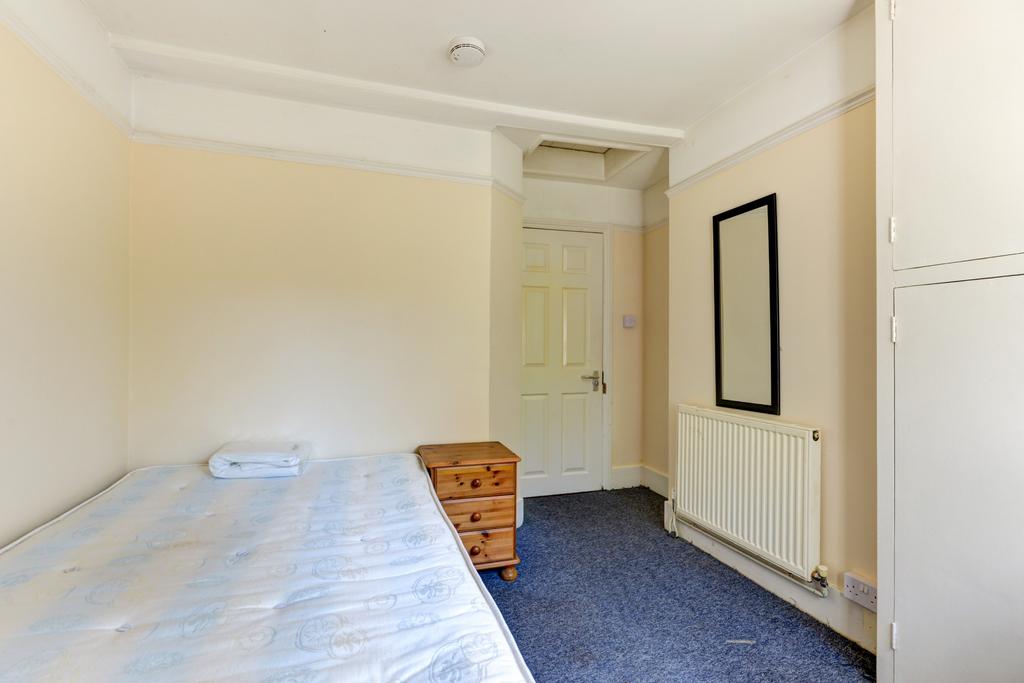 A simple and tidy single bedroom featuring a ne...