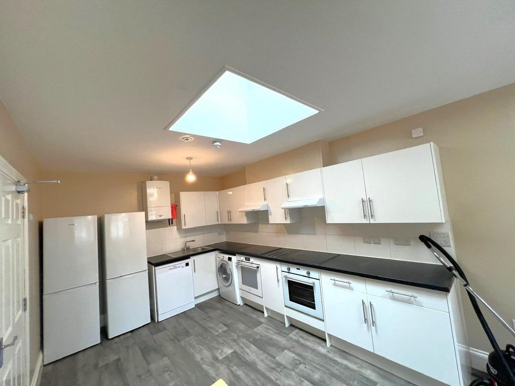 Bright modern kitchen with a long run of white ...